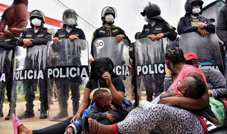 Duas mães migrantes diante do bloqueio policial na cidade peruana de Iñapari, na fronteira com o Brasil, na quinta-feira.