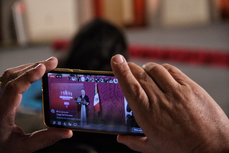 Uma pessoa grava com seu celular a entrevista coletiva matutina do presidente Andrés Manuel López Obrador.